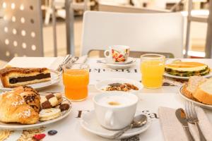 a table topped with plates of breakfast foods and drinks at LVG Hotel Collection - Riz in San Genesio ed Uniti
