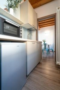 a kitchen with stainless steel appliances and a dining room at L'appartamento azzurro cielo in Fanano +10 photos