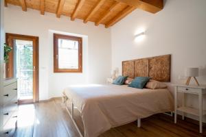 a white bedroom with a large bed with blue pillows at L'appartamento azzurro cielo in Fanano