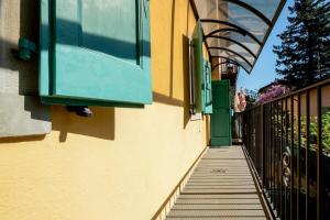 a building with a green window and a sidewalk at L'appartamento azzurro cielo in Fanano