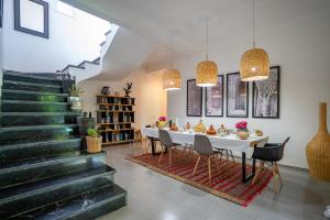 a dining room with a white table and chairs at Villa Cactus in Ben Larbi
