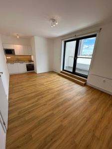 an empty room with a wooden floor and a large window at StayCentralcz- Studio in Opava