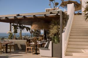 an outdoor restaurant with tables and chairs and stairs at Hotel Napa Suites (Adults Only) in Ayia Napa