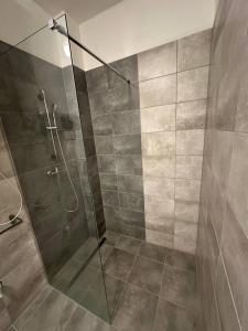 a bathroom with a shower with a glass door at StayCentralcz- Studio in Opava