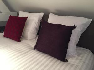 a bed with three pillows at B-Square in Bruges