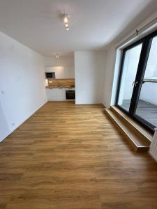 an empty room with a large window and a wooden floor at StayCentralcz- Studio in Opava +2 photos