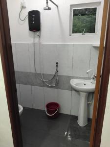 a bathroom with a sink and a toilet and a window at HG Homestay in Kota Kinabalu