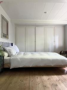 a bedroom with a large bed with white cabinets at Guest house Æbelnæs, Møn in Stege
