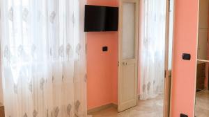 ein Zimmer mit einem Vorhang und einem Fernseher an der Wand in der Unterkunft Dimora Morge in Policoro