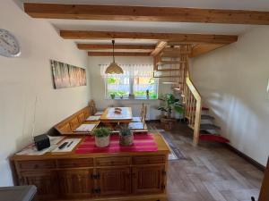 a living room with a table and a staircase at Haus Reinsdorf in Blankenburg