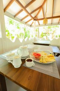 a table with a plate of food and cups of coffee at Shena resort in Habarana
