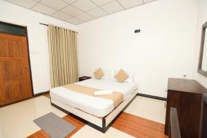 a bedroom with a bed and a wooden door at Shena resort in Habarana