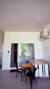 a dining room with a table and chairs in a room at The Little House in Chaloklum +8 photos