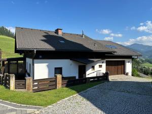 a white house with a brown roof and a driveway at Appartement Blickfang in Bruck an der Mur