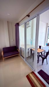 a living room with a table and a glass door at The Little House in Chaloklum
