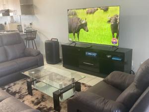 a living room with two couches and a flat screen tv at Katima VVIP in Katima Mulilo