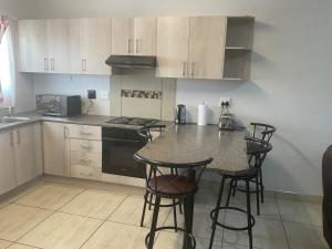 a kitchen with a counter with chairs and a table at Katima VVIP in Katima Mulilo