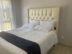 a bedroom with a large white bed with a large window at Katima VVIP in Katima Mulilo