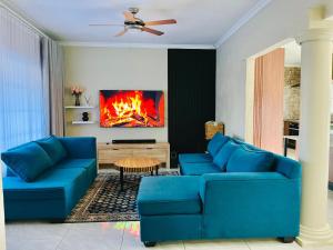 a living room with blue couches and a fireplace at No 80 At Erasmus in Polokwane