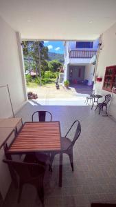a patio with a wooden table and chairs in a building at The Little House in Chaloklum