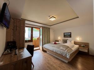 a bedroom with a bed and a desk and a television at Petererhof in Gerlos