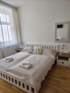 a white bedroom with a large bed with towels on it at Sankt Johannerhof in Ternitz