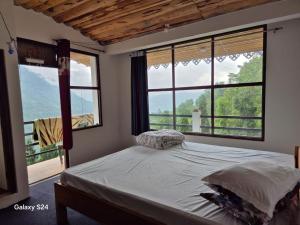 a bedroom with a bed and windows with a view at Changey Inn-Kolakham in Rishop