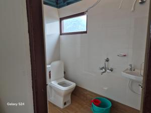 a bathroom with a toilet and a sink and a window at Changey Inn-Kolakham in Rishop
