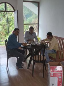 a group of men sitting at a table at Changey Inn-Kolakham in Rishop