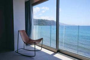 a chair sitting in front of a large window at Albergo Da Carmine in Castellabate