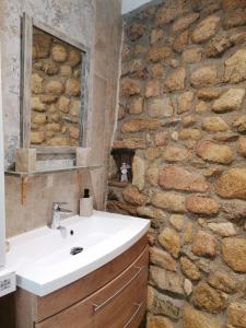 a bathroom with a sink and a stone wall at Mas de lasquiers in Saint-Paul-le-Jeune
