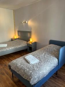 two beds in a room with two lamps on them at La compagnie du bourg in Le Châtelard