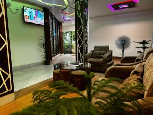 a living room with a couch and a tv at Hotel Grand Shah Kamal in Sylhet