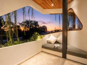 a balcony with a view of the sunset at Modern 1-BR Loft with Art Deco Style Shared Pool in Canggu