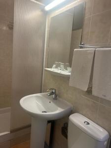 a bathroom with a sink and a toilet and a mirror at Le Terminus in Tarascon
