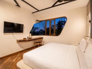 a bedroom with a white bed and a window at Modern 1-BR Loft with Art Deco Style Shared Pool in Canggu