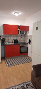 a kitchen with red cabinets and a white refrigerator at Monteurwohnungwgapartment In 50129 in Bergheim