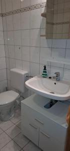 a white bathroom with a toilet and a sink at Monteurwohnungwgapartment In 50129 in Bergheim