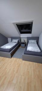 two beds in a room with wooden floors at Monteurwohnungwgapartment In 50129 in Bergheim +2 photos