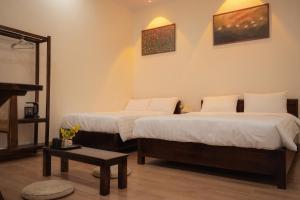 a hotel room with two beds and a table at Tan Ca Home & Studio Ninh Bình in Kỳ Vĩ +26 photos
