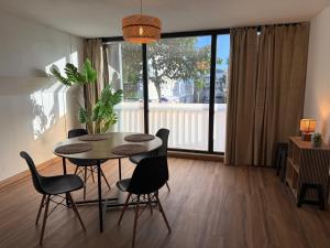 a dining room with a table and chairs and a large window at Coeur SAINT-PAUL in Saint-Paul