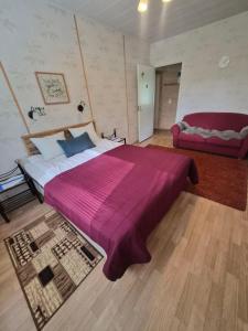 a bedroom with a large bed with a purple blanket at MiniMani House with Sauna in Sorsakoski