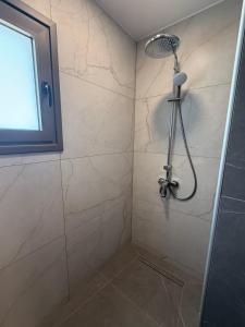 a shower with a shower head in a bathroom at IOLENA Two Bedroom SEAVIEW APT in Pyla +8 photos