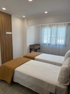 a bedroom with two beds and a table in it at IOLENA Two Bedroom SEAVIEW APT in Pyla