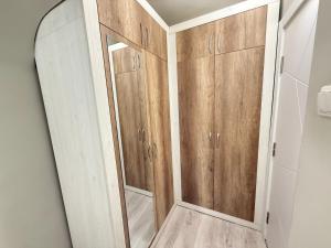 a bathroom with wooden cabinets and a mirror at Catherdral Apartments with Parking in Varna City