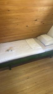 a bed in a room with a wooden wall at Planinski vrh in Bajina Bašta