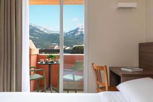 a hotel room with a view of a table and chairs at Kyriad Chambéry Centre - Hôtel et Résidence in Chambéry