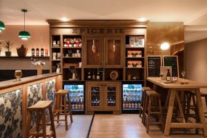a bar in a restaurant with a counter and stools at Kyriad Chambéry Centre - Hôtel et Résidence in Chambéry