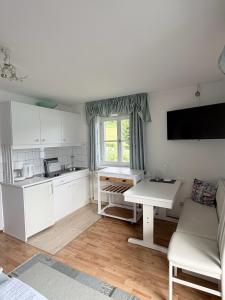 a kitchen with white cabinets and a white table at Pension Semler in Mondsee