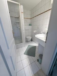 a bathroom with a toilet and a sink and a shower at Pension Semler in Mondsee +53 photos